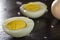 Slices of boiled hard eggs on a dark slate with sea salt