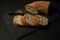 Slices of bread with crumbs and a knife on a black board background. View from above. World homemade