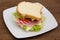 Slices of bread with ham and salad on wood
