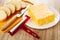 Slices of bread, knife on cutting board, marble cheese in plate, cheese cutter on wooden table