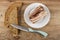 Slices of bread, knife, piece of salted lard in white plate on wooden table. Top view