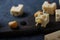 Slices of cheese with large holes and scamorza balls on a wooden Board, close-up.