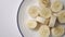 Slices of chopped peeled banana closeup on a white plate with a blue border. Juicy fruits and carbohydrates for vegan nutrition