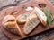 Slices of ciabatta with rosemary herb on the serving wooden tray