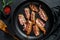 Slices of crispy hot fried cooked bacon. Farm organic meat. Black background. Top view