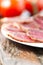 Slices of cured meet on plate vertical shallow depth of field