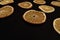 Slices of dried oranges lay in pattern at black background, copy space,