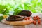 Slices of eggplant roasted on a grill, served with cherry tomato on a wooden board