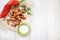 Slices of fried croutons with sour cream sauce, red pepper and garlic cloves close up on a white wooden boards. Flat lay. Copy