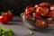 Slices of fried pork sausages in a transparent bowl with parsley and tomatoes