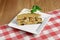 Slices of fruitcake. One piece of vanilla cake with dryed fruit served on a square plate over wooden background