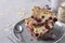 Slices of homemade cottage cheese casserole with oatmeal and cherry on a gray plate on a gray concrete background, closeup,