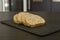 Slices of homemade multigrain bread on black slate board