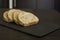 Slices of homemade multigrain bread on black slate board