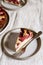 Slices of Homemade Ricotta Plum Cake on plates on beige linen tablecloth