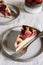 Slices of Homemade Ricotta Plum Cake on plates on beige linen tablecloth