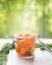 Slices of homemade smoked salmon with dill and lemon in glass jar on table at blurred nature background. Healthy food concept.