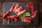 Slices of Italian prosciutto crudo or jamon with fresh basil leaves on a black background.