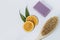 Slices of juicy orange, a body brush and handmade lavender soap on a blue background. The concept of home Spa