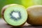 slices kiwi close up and fresh whole kiwi fruit wooden and nature green background