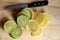 Slices of lemons and limes on blonde-tone cutting board