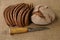 Slices and  loaf of rye bread and finnish knife puukko on burlap