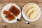 Slices of marmalade in plate, fork, pieces of bread in plate on wooden table . Top view