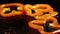 Slices of orandge bell pepper fall down on brown wooden board with water drops