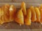 Slices of orange tomato on the wooden background in macro. Chopped tomato on a cutting board.