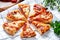 Slices of pizza with mozzarella and spicy salami on a plate on the table with decorations. Traditional Neapolitan Italian fast