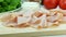 Slices of pork ham on wooden board, making sandwich, ingredients on background