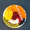 Slices of ripe exotic fruits on white plate. Kiwi, mango, raspberry, blueberry and persimmon. Fruits assortment. Top view. Healthy