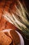 Slices of rye wholegrain bread on white plate, wheat ears on wooden boards background, rustic kitchen table. Homemade bread,