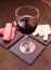 Slices of salami and wine on slate plates on wooden seen up close