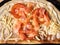 Slices of salmon and tomato, grated cheese on round thin baked dough base greased with sauce. Macro detailed top view.