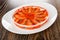 Slices of salted pink salmon in jar on plate on wooden table