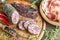 Slices of saucisson, jamon and basturma on the wooden board