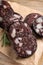 Slices of tasty blood sausage with rosemary on wooden table, closeup