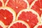 Slices of tasty grapefruit as background, top view