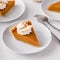 Slices of traditional pumpkin pie in a light and bright setting