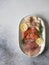 Slices of various salted fish - salmon, muksun, oily fish on an oval white plate on a gray background. Top view. Copy space