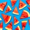 Slices of a watermelon triangular in shape on a blue background. Summer time concept