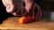 slicing carrots. a man cuts a carrot into two halves.