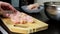 slicing chicken meat at cutting board