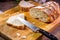 slicing ciabatta bread on a board with a serrated knife