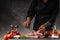 Slicing fresh meat, pork ribs on a background of fresh vegetables and a gray wall with space