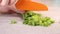 Slicing green onion on a wood cutting board