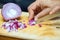 Slicing onions. The cook`s hands carefully hold the knife and cut the onion. Cooking at home in close-up