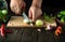 Slicing onions on a cutting board by the hands of a chef for pickling or salt in a jar with cucumbers and spices. Menu for