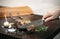 Slicing organic roast beef roll on wood table with ingredients